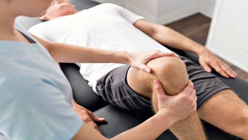 پزشک در حال معاینه بیمار مبتلا به آرتروز زانو