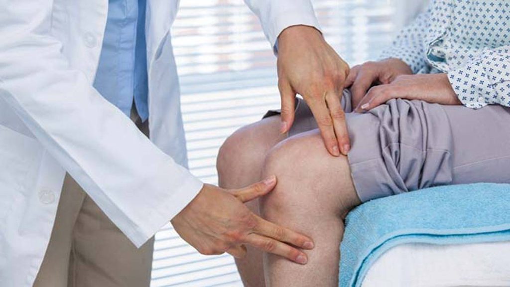پزشک در حال درمان بیمار مبتلا به آرتروز زانو